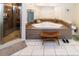 Relaxing bathroom featuring a corner jacuzzi tub with tiled surround, glass shower, and bench at 11945 Darwin Ave, New Port Richey, FL 34654
