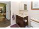 Neutral-toned powder room featuring a small vanity, mirror, and adjacent toilet and doorway at 11945 Darwin Ave, New Port Richey, FL 34654
