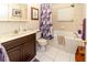 Well-lit bathroom featuring a vanity, toilet, and a relaxing jacuzzi bathtub with showerhead at 11945 Darwin Ave, New Port Richey, FL 34654