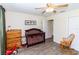 Bright bedroom with wood-look floors, ceiling fan, and dark wood baby crib at 11945 Darwin Ave, New Port Richey, FL 34654