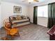 Cozy bedroom features wood-look flooring, a comfortable daybed and a rocking chair at 11945 Darwin Ave, New Port Richey, FL 34654