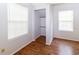 Clean bedroom with laminate wood flooring, closet nook, and bright windows at 11945 Darwin Ave, New Port Richey, FL 34654