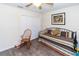 Well-lit bedroom offers wood-look flooring, a daybed, a rocking chair, and a double door closet at 11945 Darwin Ave, New Port Richey, FL 34654