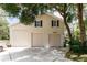 Spacious garage with multiple bays and an upper level, shaded by mature trees at 11945 Darwin Ave, New Port Richey, FL 34654
