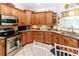 Kitchen featuring wooden cabinetry, granite countertops and stainless steel appliances at 11945 Darwin Ave, New Port Richey, FL 34654