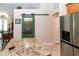 Open kitchen with granite countertops, stainless steel refrigerator, sliding pantry door, and breakfast nook at 11945 Darwin Ave, New Port Richey, FL 34654