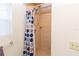 Full tiled stand up shower with curtain, window and towel rack at 11945 Darwin Ave, New Port Richey, FL 34654