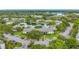 Aerial view of a condo complex featuring a central pond, mature trees, and ample parking spaces at 1207 Pine Ridge W Cir # H2, Tarpon Springs, FL 34688