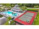 Aerial view of community pool and tennis courts, surrounded by mature trees and landscaping at 1207 Pine Ridge W Cir # H2, Tarpon Springs, FL 34688
