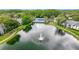 Scenic aerial view of a community lake with fountain and surrounding lush landscaping at 1207 Pine Ridge W Cir # H2, Tarpon Springs, FL 34688