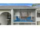 Second floor balcony with blue outdoor furniture overlooking the manicured grounds at 1207 Pine Ridge W Cir # H2, Tarpon Springs, FL 34688