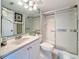 Bright bathroom featuring a modern vanity, toilet, and a shower with sliding glass doors at 1207 Pine Ridge W Cir # H2, Tarpon Springs, FL 34688