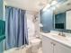 Well-maintained bathroom featuring a shower and blue shower curtain at 1207 Pine Ridge W Cir # H2, Tarpon Springs, FL 34688