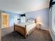 The primary bedroom has a wood bed frame, with blue walls and carpet flooring at 1207 Pine Ridge W Cir # H2, Tarpon Springs, FL 34688