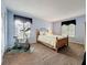 The primary bedroom has a wood bed frame, with blue walls and carpet flooring at 1207 Pine Ridge W Cir # H2, Tarpon Springs, FL 34688