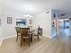 Bright dining room with table set for four, featuring light wood flooring and elegant decor at 1207 Pine Ridge W Cir # H2, Tarpon Springs, FL 34688