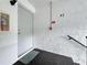 Close-up of condo entryway featuring textured walls, door, fire extinguisher, and unit number H2 at 1207 Pine Ridge W Cir # H2, Tarpon Springs, FL 34688