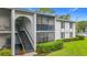 Well-maintained condo building featuring landscaped grounds, exterior stairs and walkways at 1207 Pine Ridge W Cir # H2, Tarpon Springs, FL 34688
