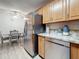The kitchen has stainless steel appliances, gray countertops, and light wood cabinets with dining area at 1207 Pine Ridge W Cir # H2, Tarpon Springs, FL 34688