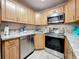 Bright kitchen features stainless steel appliances, light wood cabinets, and gray countertops at 1207 Pine Ridge W Cir # H2, Tarpon Springs, FL 34688