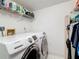 Bright laundry room featuring a Samsung washer and dryer with storage shelves at 1207 Pine Ridge W Cir # H2, Tarpon Springs, FL 34688