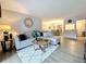 Bright living room with a stylish sectional sofa, round wooden coffee table, and decorative mirror at 1207 Pine Ridge W Cir # H2, Tarpon Springs, FL 34688