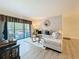 Relaxing living room with balcony access, features a large sectional couch and stylish decor at 1207 Pine Ridge W Cir # H2, Tarpon Springs, FL 34688