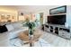 Inviting living space featuring a modern entertainment center and open access to the dining area at 1207 Pine Ridge W Cir # H2, Tarpon Springs, FL 34688