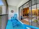 Cozy screened patio with blue chairs overlooks lush landscaping, and features a dart board for recreation at 1207 Pine Ridge W Cir # H2, Tarpon Springs, FL 34688