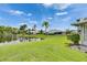Expansive lawn with serene pond views, complemented by mature palm trees at 123 Glendower Cir # 123, Sun City Center, FL 33573