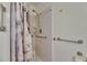 Bathroom features a walk-in shower with safety bars and neutral marble-look shower curtain at 123 Glendower Cir # 123, Sun City Center, FL 33573