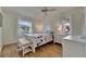 Bright bedroom with hardwood floors, a ceiling fan, and two windows allowing natural light to flood the space at 123 Glendower Cir # 123, Sun City Center, FL 33573