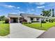Charming single-story home with a well-manicured lawn, mature landscaping, and a covered carport at 123 Glendower Cir # 123, Sun City Center, FL 33573