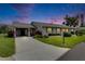 Charming single-story home with a well-manicured lawn, mature landscaping, and a covered carport at 123 Glendower Cir # 123, Sun City Center, FL 33573