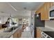 Open-concept kitchen with stainless steel appliances and granite countertops flowing into the dining and living spaces at 123 Glendower Cir # 123, Sun City Center, FL 33573