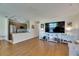 Inviting open-concept living room featuring wood floors, a media center, and a view into the kitchen at 123 Glendower Cir # 123, Sun City Center, FL 33573