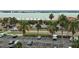 Aerial shot of a parking lot with palm trees, storefronts and a stunning waterfront backdrop at 1230 Gulf Blvd # 601, Clearwater Beach, FL 33767