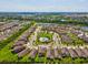 Aerial view features a community with a swimming pool, surrounded by lush landscaping and ponds at 1325 Custer Bayou St, Ruskin, FL 33570