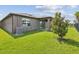The backyard features a covered patio, lush green grass, and mature tree landscaping at 1325 Custer Bayou St, Ruskin, FL 33570