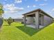Well-maintained backyard with green lawn, covered patio, and fenced perimeter offers outdoor living at 1325 Custer Bayou St, Ruskin, FL 33570