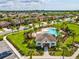 Aerial view of community pool and recreation center, with lush landscaping and mature palm trees at 1325 Custer Bayou St, Ruskin, FL 33570