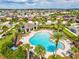 Sparkling community pool area with a covered patio, lounge chairs, and palm trees in a beautiful neighborhood at 1325 Custer Bayou St, Ruskin, FL 33570