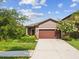 Inviting single-Gathering home featuring a well-maintained lawn and an attached two-car garage at 1325 Custer Bayou St, Ruskin, FL 33570