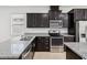 Modern kitchen with dark cabinets, stainless steel appliances, and granite countertops at 1325 Custer Bayou St, Ruskin, FL 33570