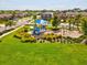 Community playground with blue slides, swings, and a shade structure, surrounded by lawns and residential homes at 1325 Custer Bayou St, Ruskin, FL 33570
