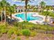 Resort-style pool area surrounded by lush greenery, palm trees, and comfortable lounge chairs, perfect for relaxation at 1325 Custer Bayou St, Ruskin, FL 33570