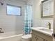 Well-lit bathroom featuring white subway tile, gray vanity, and shower with blue-patterned curtain at 14230 86Th Ter, Seminole, FL 33776