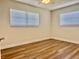 Bright bedroom featuring two windows, ceiling fan, and stylish wood flooring at 14230 86Th Ter, Seminole, FL 33776