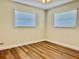 Bedroom with two windows and ceiling fan showcasing modern wood flooring at 14230 86Th Ter, Seminole, FL 33776