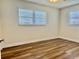 A bright bedroom featuring modern laminate flooring and lots of natural light from two large windows at 14230 86Th Ter, Seminole, FL 33776